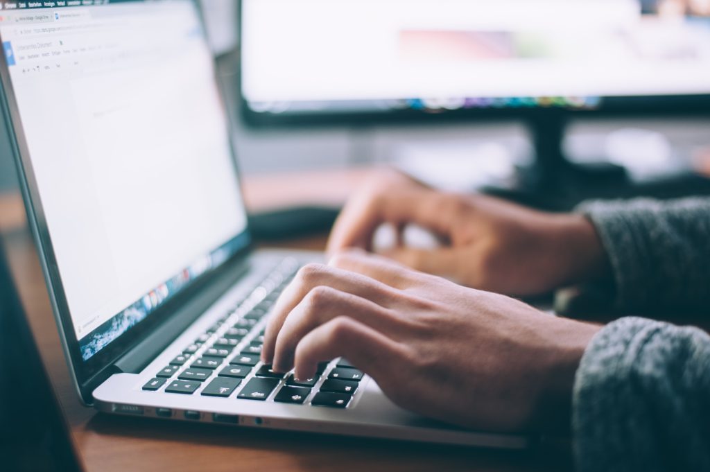 man typing on laptop